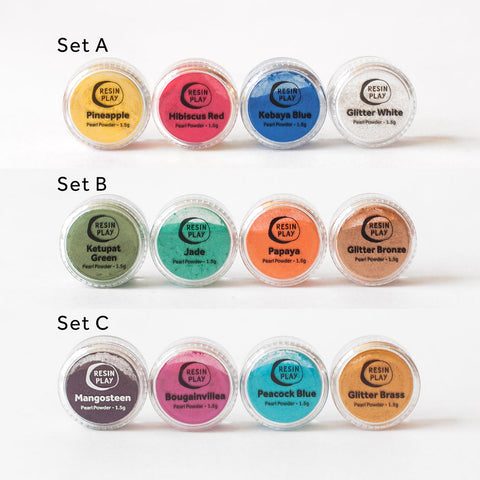 3 rows of 4 1.5g mica pearl powder pigment sets. First row Set A consists of Pineapple (Yellow), Hibiscus Red, Kebaya Blue, and Glitter White. Second row Set B consists of Ketupat Green, Jade (Green), Papaya (Orange), and Glitter Bronze. Third row Set C consists of Mangosteen (Purple), Bougainvillea (Pink), Peacock Blue and Glitter Brass. 